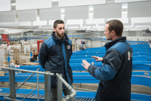 maître de stage discute avec alternant entrepôt