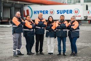 6 hommes et femmes souriants posant devant un camion U