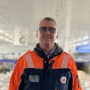Thierry Guillet, nouveau Directeur du site logistique U LOG de Savigny-en-Véron, en tenue de travail de la logistique avec le logo U, souriant, dans un entrepôt U LOG.